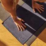 High-quality hot yoga mat rolled out in a bright studio, designed for grip and sweat absorption during intense yoga sessions.