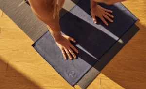 High-quality hot yoga mat rolled out in a bright studio, designed for grip and sweat absorption during intense yoga sessions.