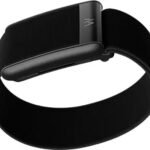 A WHOOP Strap 5.0 wearable on a wrist next to smart home gym gear, i