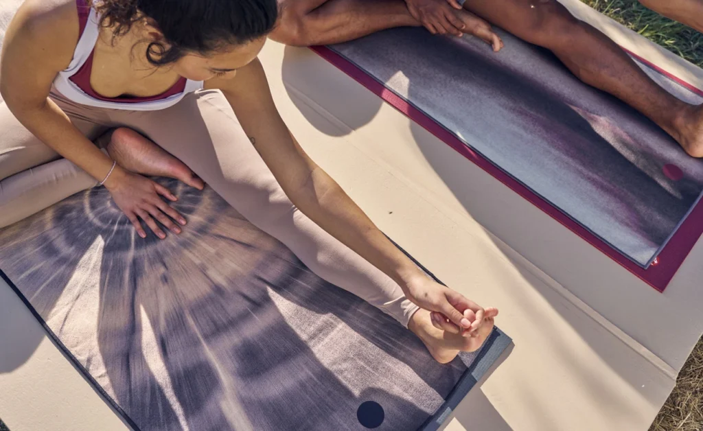 High-quality hot yoga mat rolled out in a bright studio, designed for grip and sweat absorption during intense yoga sessions.