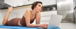 Best Home Workout Plans Without Equipment – Woman Using Laptop on Yoga Mat