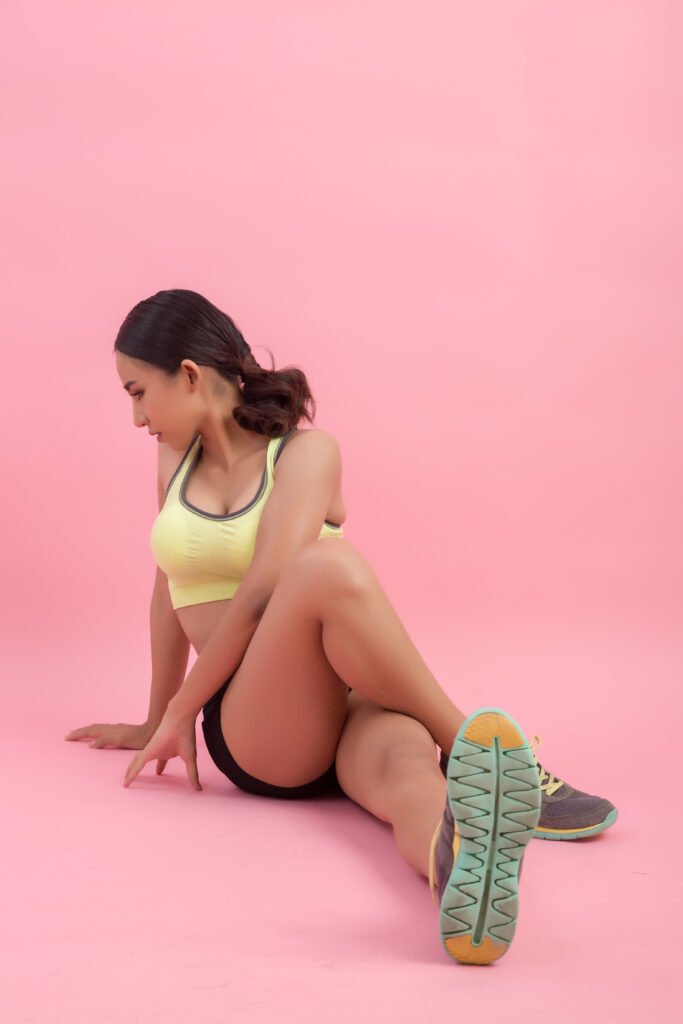 Best At-Home Booty Workout Gear 2025 5 Woman performing glute kickback exercise on a pink yoga mat while following an online fitness class on a tablet.