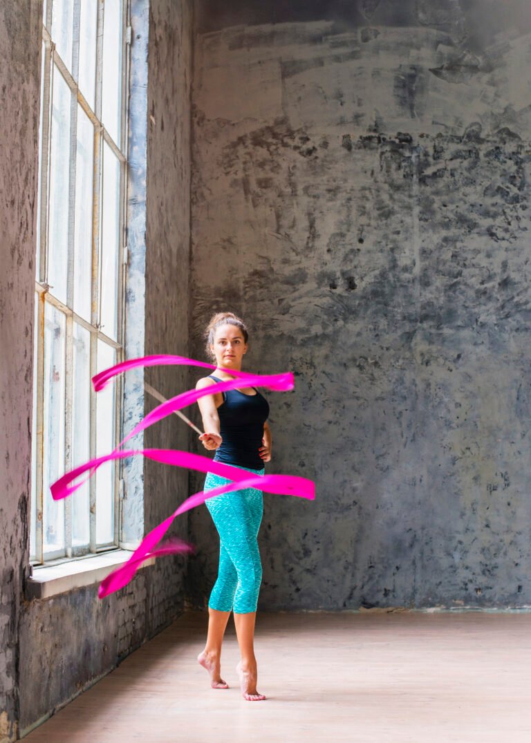 Woman exercising in gym using the best smart weighted hula hoop 2025 to tone her waist and improve core strength.